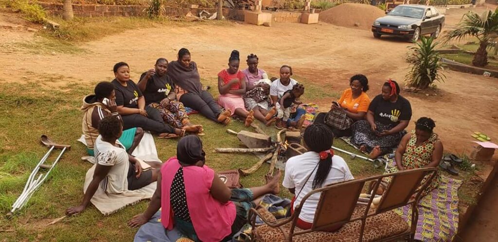 PHOTO: Women with special abilities burduned by Cameroon Anglophone Crisis sit round a fire place in a heart to heart talk while CSO. GIDICom,offer them relief talk. Photo credit: GIDICom
